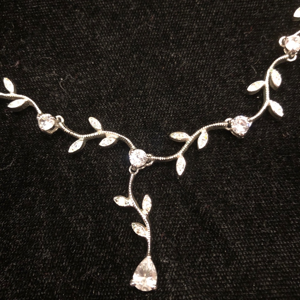 Silver crystal necklace with leaf pattern.